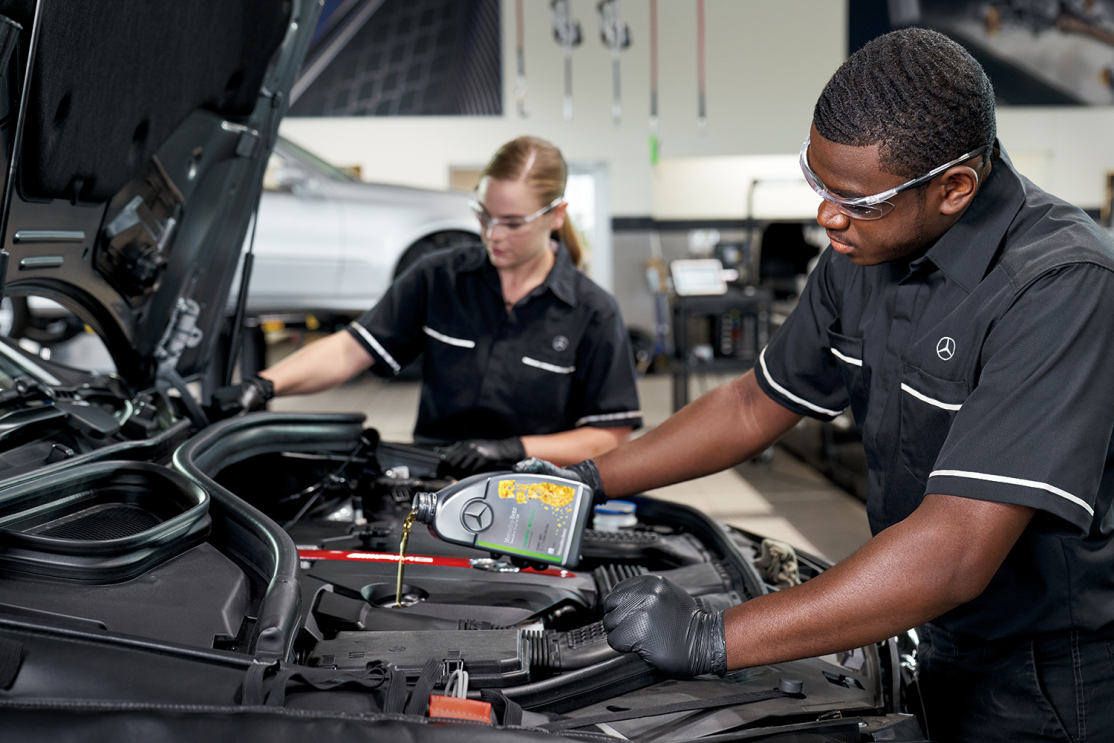 Mercedes-Benz technicians performing an oil change