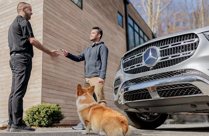 Man with dog hands keys to a Mercedes-Benz technician