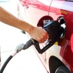 Close-up of pumping gas into a red car